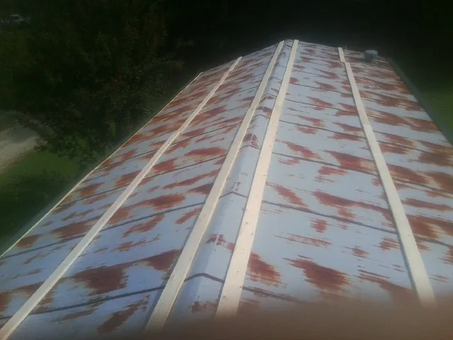 Rusted metal roof panels with new wood purlins before replacement — Storm Damage Roof Repair in Washington Depot by Roofing Brothers