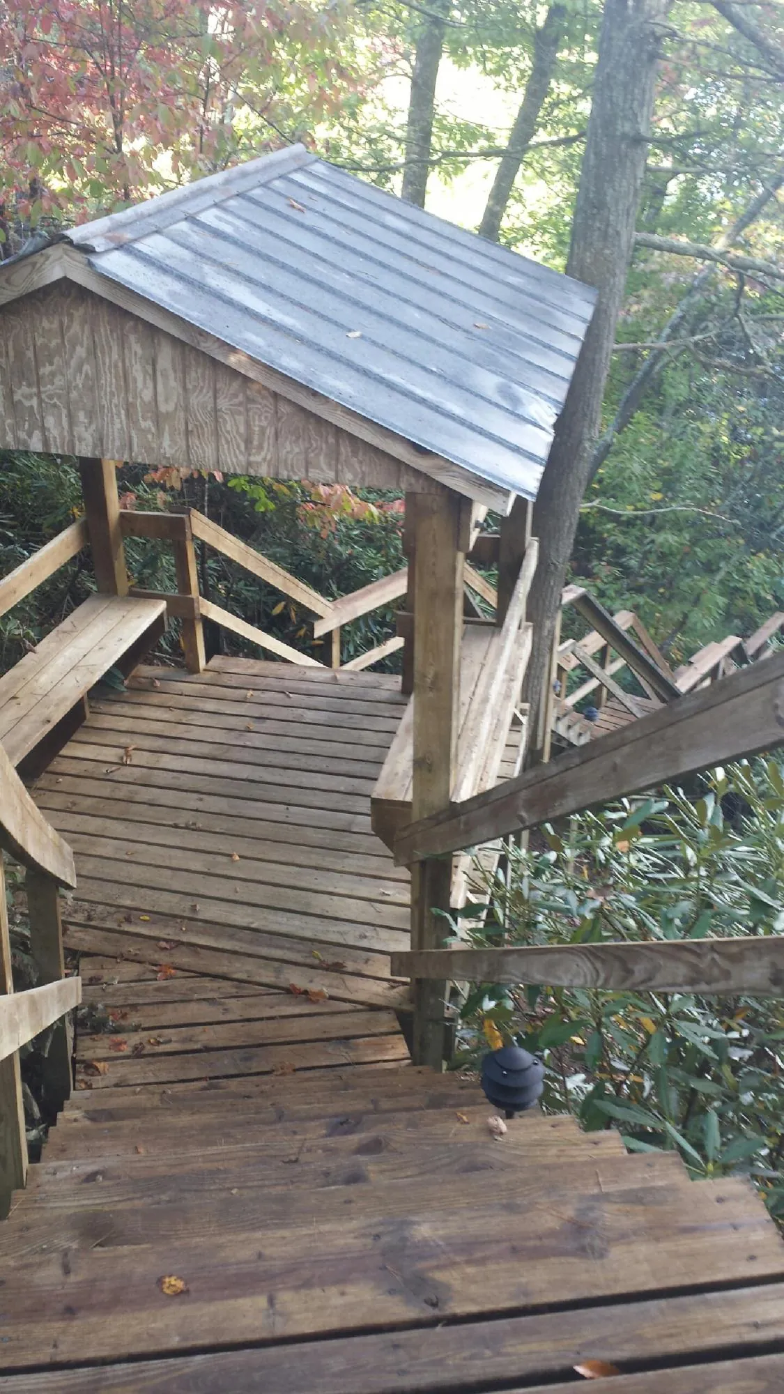 Metal roofed shelter over wooden steps on a wooded walkway — Skylight Repair & Installation work by our crew in Washington Depot