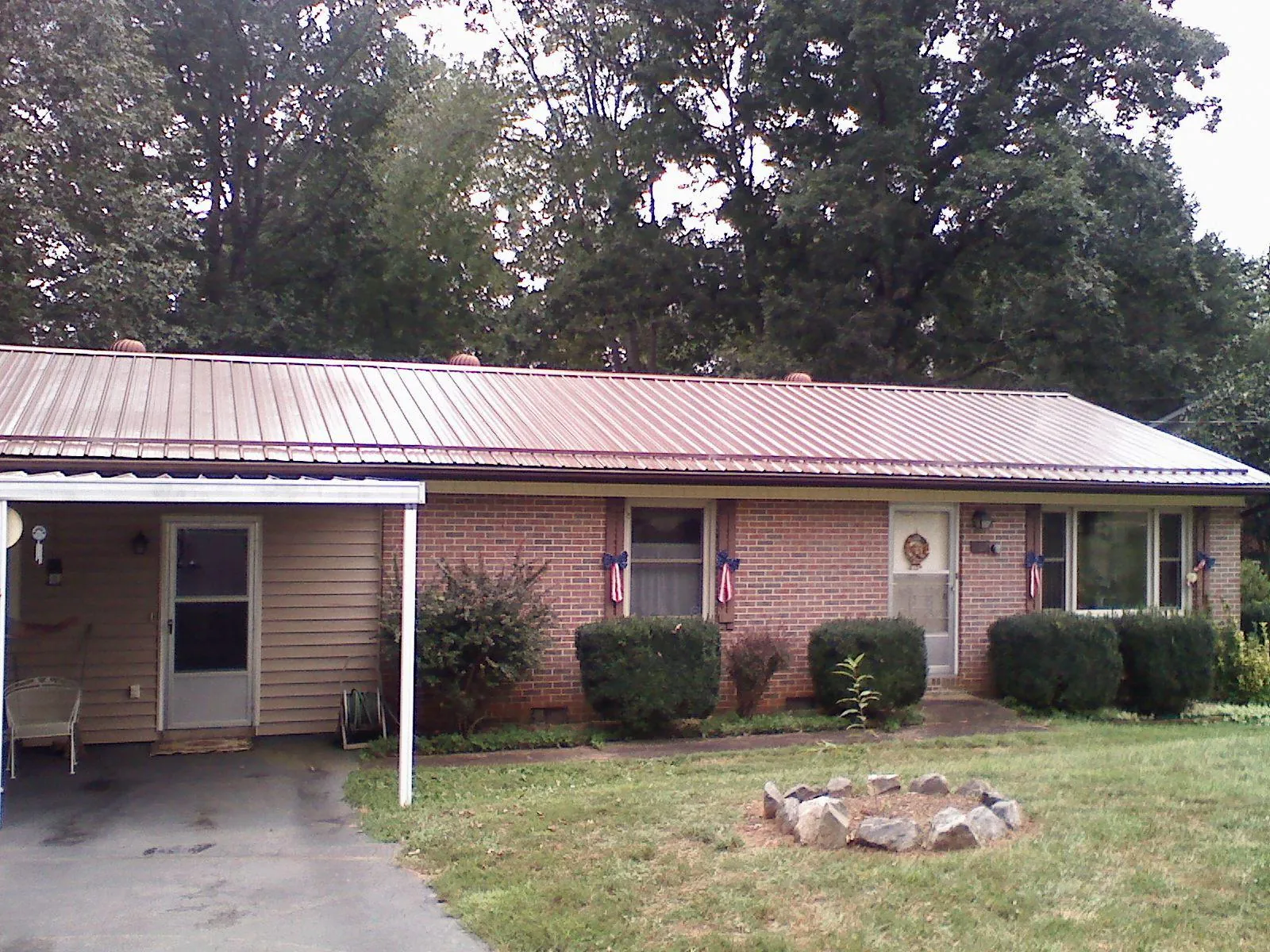 Bronze metal roof and carport on a brick ranch home — Roof Repair work by our crew in Washington Depot